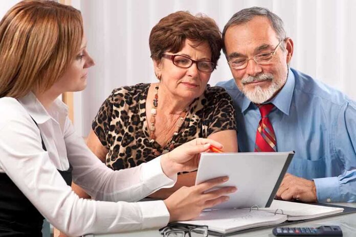 A financial advisor discussing documents with an elderly couple